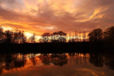 Sunset over the lake. Red sky. Beautiful landscape