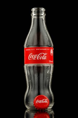 LVIV, UKRAINE - October 13, 2021: Coca cola empty bottle on black background