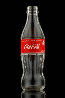 LVIV, UKRAINE - October 13, 2021: Coca cola empty bottle on black background