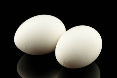 Two white eggs black background