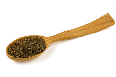 Dried basil seasoning in a wooden spoon
