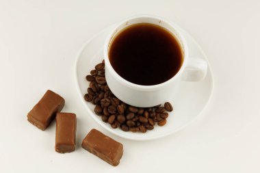 Coffee in a white cup and chocolates