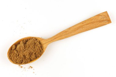 Ground coriander seasoning in a wooden spoon isolate
