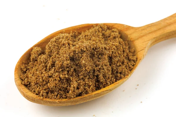 Ground coriander seasoning in a wooden spoon isolate