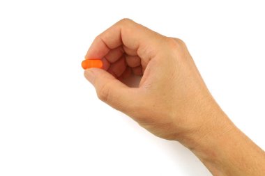 Orange pill in hand close-up