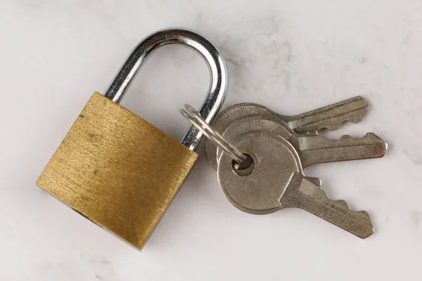 Small lock with keys. Locked Golden Padlock on the white background