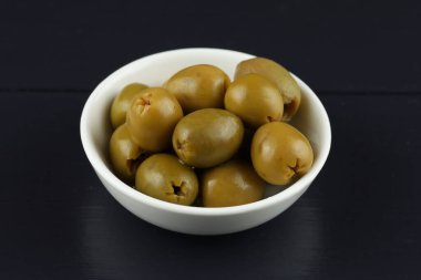Green pitted olives in a white plate. Healthy foods.