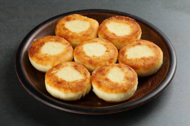 Tabakta kaymaklı börek. Köy arka planında süzme peynir