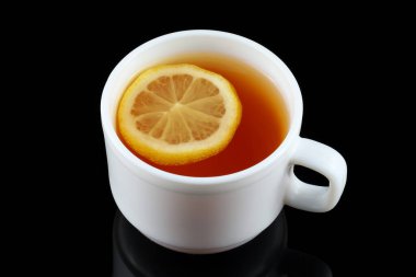 Beyaz bardakta limonlu çay. Siyah arkaplanda çay