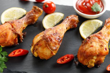 Kızarmış tavuk budu, domates ve limon..