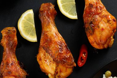 Kızarmış tavuk bacağı, acı biber ve limon..