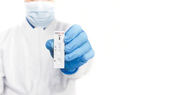 The doctor showing Covid-19 positive test result of the antigen rapid test kit on white background and copy space,Coronavirus infectious protect concept