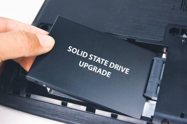 Bir teknisyen dizüstü bilgisayara Solid State Drive (SSD) yükler