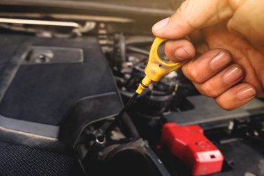 Tamirci el, motor vagonunu yağlamak için yağ çubuğunu çekiyordu.
