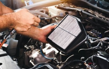 Otomatik mekanik eldeki hava filtresi hava üfleme silahıyla toz ve temizlik yapıyor.