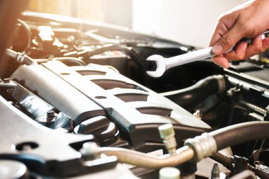 Otomatik mekanik el, oto tamirhanesindeki motor bölmesinde anahtarı açık tutuyor.