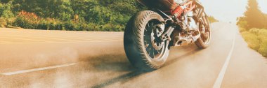Motorcycle parked alone on a sunny road in the evening