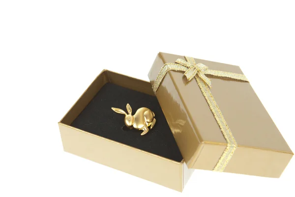 Χρυσή κουνέλι σε ένα κιβώτιο δώρων με Χρυσή κορδέλα που απομονώνονται σε λευκό — Φωτογραφία Αρχείου