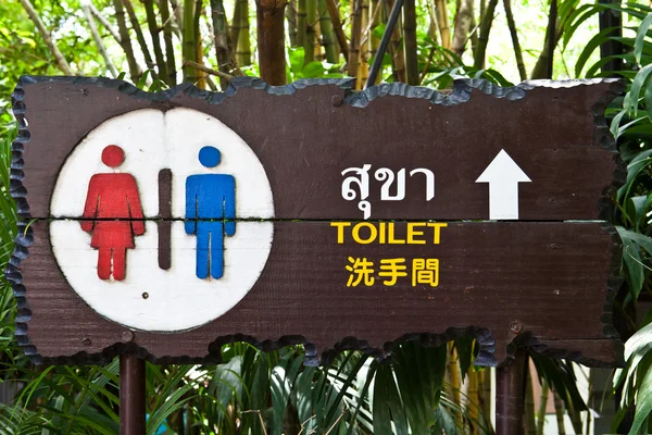 Znak publicznych toalet w trzech językach, tajski, angielski i chi — Zdjęcie stockowe