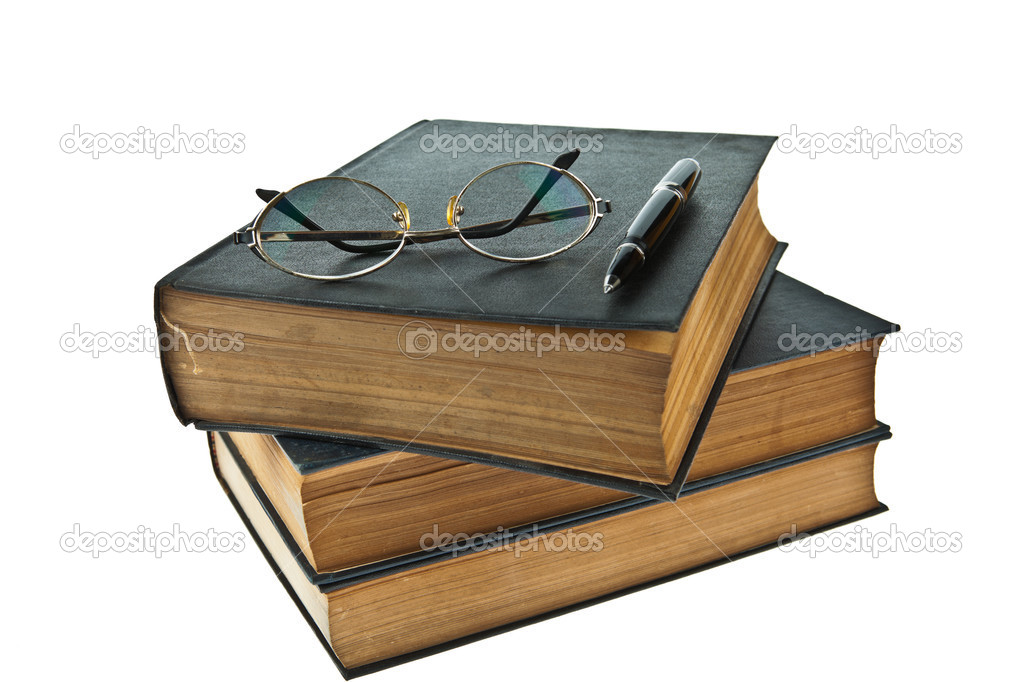 Stack of old books with eye glasses and pen isolated on white ba