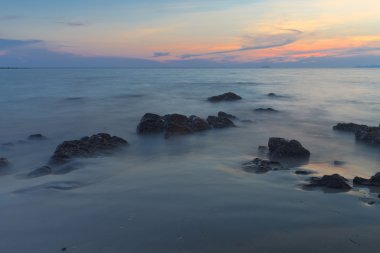 Deniz ve mavi gökyüzü ile sahilde Rock