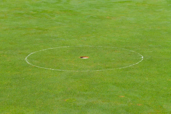 Buraco de golfe com a grama verde — Fotografia de Stock