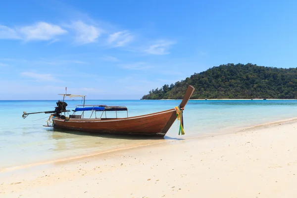Лодка на пляже с голубым небом — стоковое фото