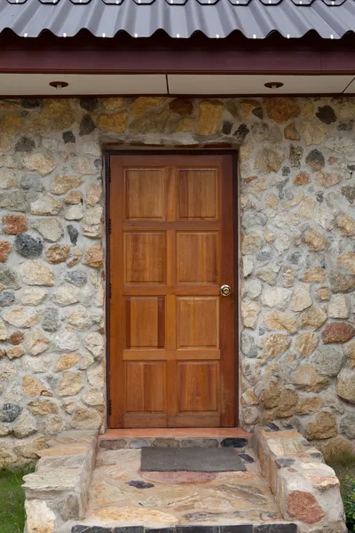 Porta de madeira na casa apedrejada — Fotografia de Stock