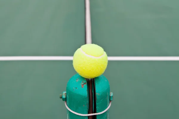 Pista de tenis con pelota en un poste neto — Foto de Stock