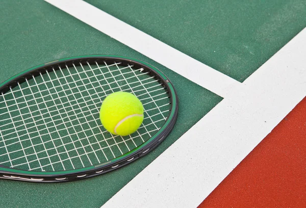 Pista de tenis en la línea base con pelota y raqueta — Foto de Stock