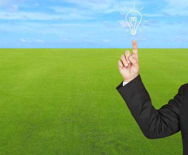 Business with bulb on green grass and blue sky — Stock Photo, Image