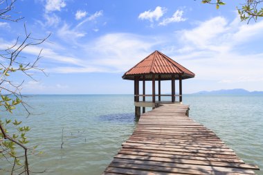 Wooden pier with pavilion in the sea clipart