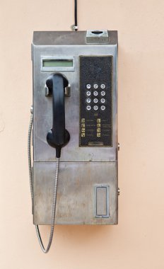 Duvardaki ankesörlü telefon.