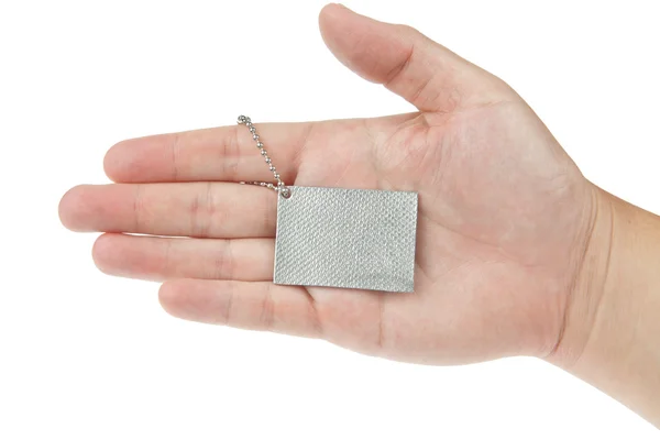 Hand met zilveren belangrijkste tag — Stockfoto