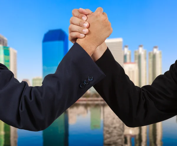 Affärsman handslag med att bygga bakgrund — Stockfoto