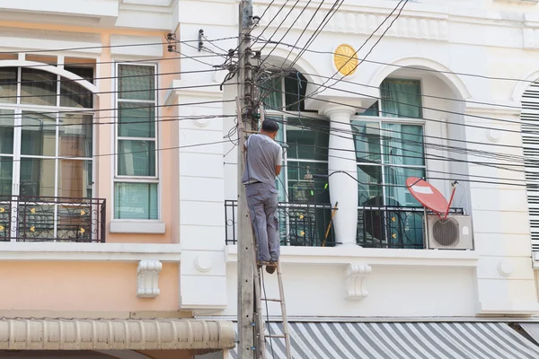 Technik pracy z kabla przed domem — Zdjęcie stockowe