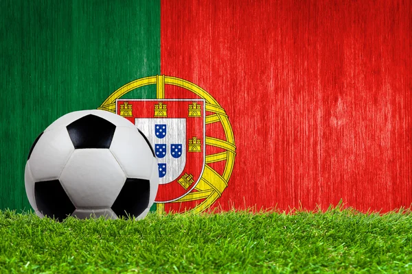 Balón de fútbol sobre hierba con fondo de bandera de Portugal — Foto de Stock