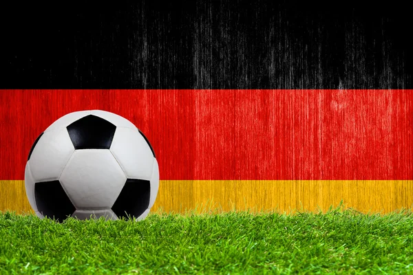 Fußball auf Rasen mit Deutschland-Fahne Hintergrund — Stockfoto