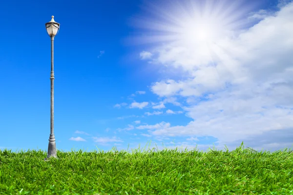 Streetlamp on artificial grass under blue sky — Stock Photo, Image