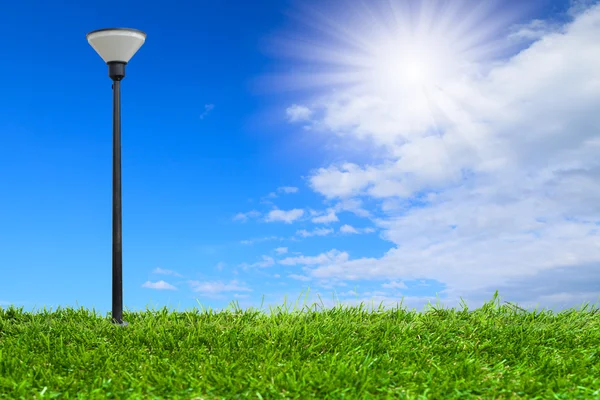 Streetlamp on artificial grass under blue sky — Stock Photo, Image