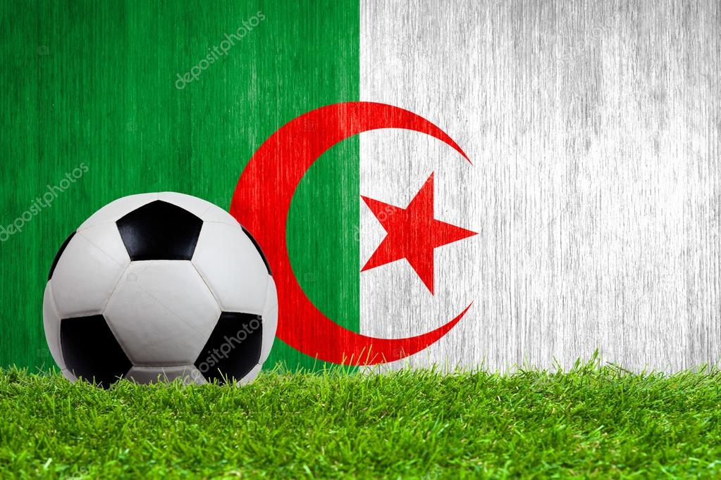 Soccer ball on grass with Algeria flag background