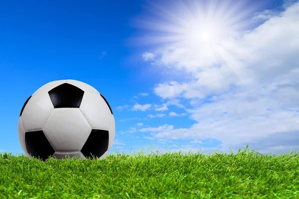 Pelota de fútbol sobre hierba con cielo azul —  Fotos de Stock