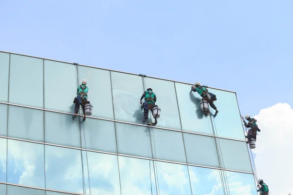 Grupo de trabajadores servicio de limpieza de ventanas en edificio de gran altura — Foto de Stock