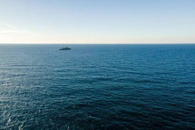 Ufukta savaş gemisi olan deniz insansız hava aracı tarafından gökyüzü görüntüsü.