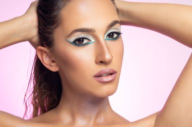 Parlak arka planda poz veren manken. Güzel genç kadın portresi.