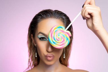 Beauty fashion model girl wiht colourful lollipop. Beautiful young woman portrait.