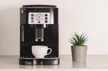 Mutfakta kahve fincanı olan bir kahve makinesi..