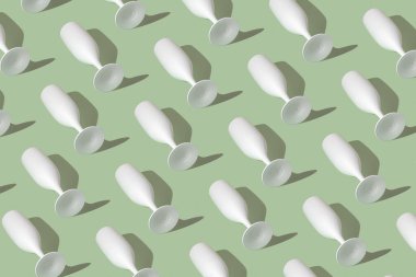 Yeşil arka planda beyaz şampanya kadehi olan bir desen. Asgari parti konsepti.