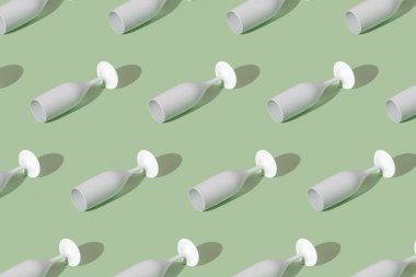 Yeşil arka planda beyaz şampanya kadehi olan bir desen. Asgari parti konsepti.