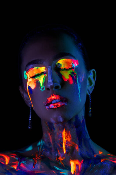 Fashion model in neon light with fluorescent paint. Body Art design in UV over dark background.